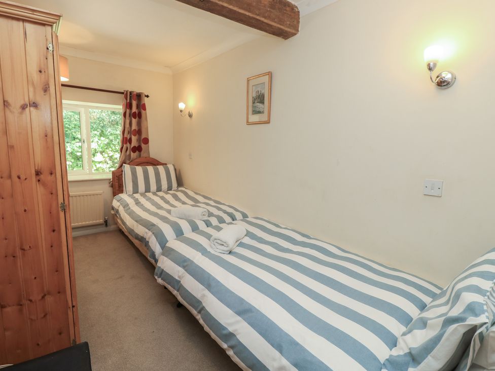A bedroom with twin beds and a wardrobe at Byre Cottage 3 Sullington near Storrington