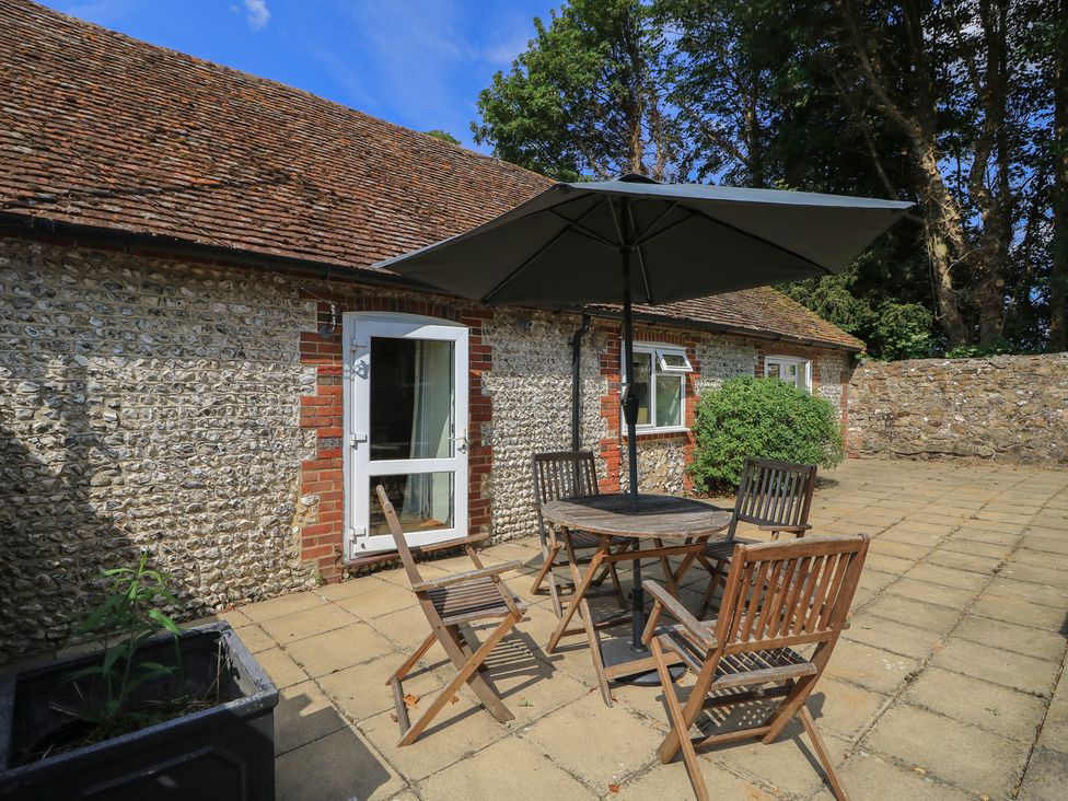 An outdoor patio with a table and chairs at Byre Cottage 3 Sullington near Storrington