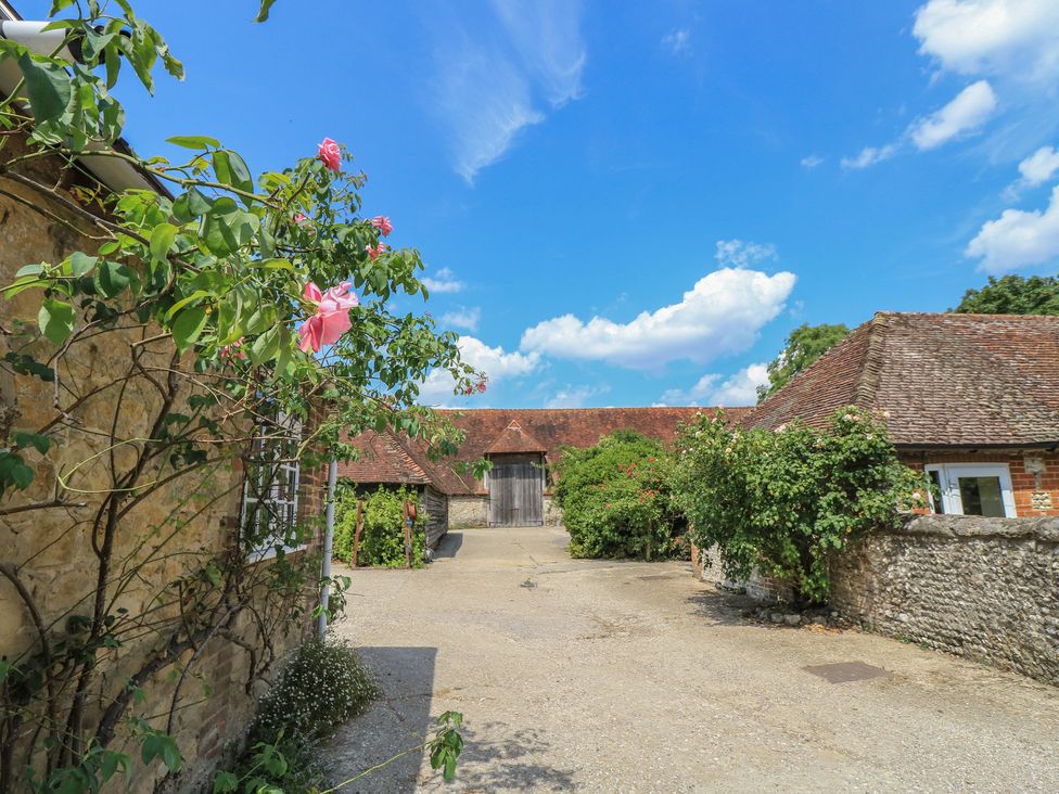 An outdoor space with flowers and buildings at Byre Cottage 3 Sullington near Storrington