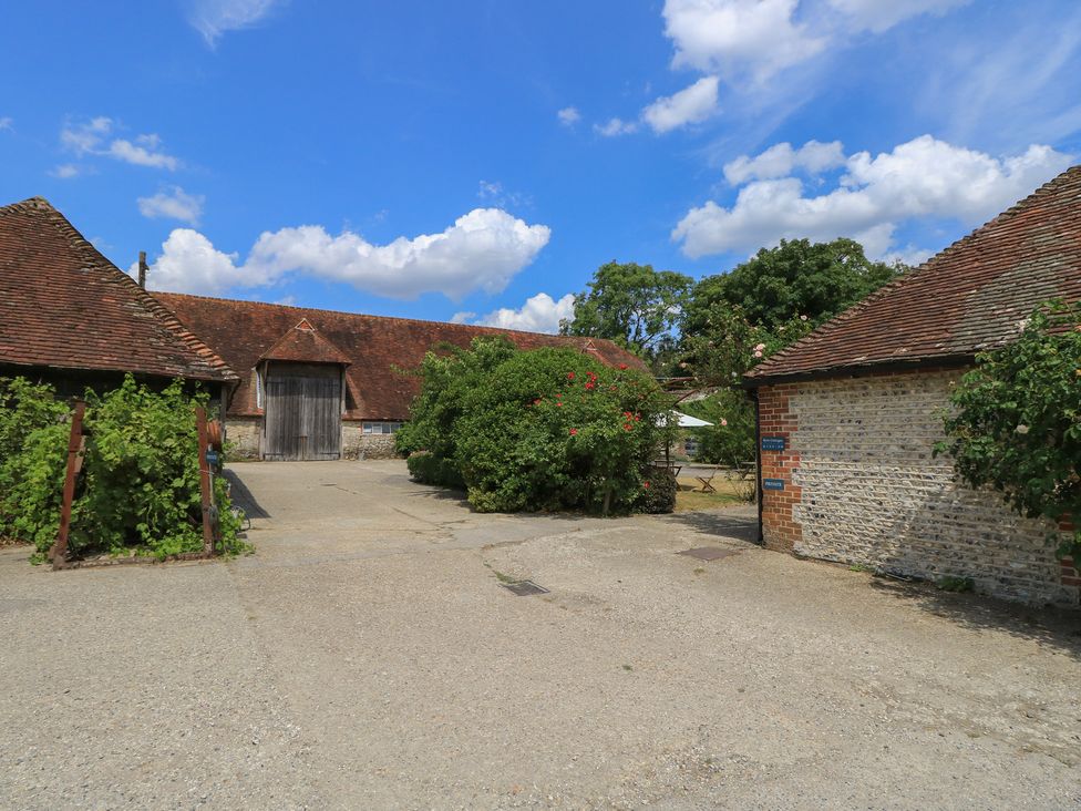 An outdoor area with a barn and vegetation at Byre Cottage 3 Sullington near Storrington