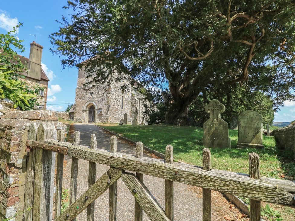 A church with gravestones and a path at Byre Cottage 3 Sullington near Storrington