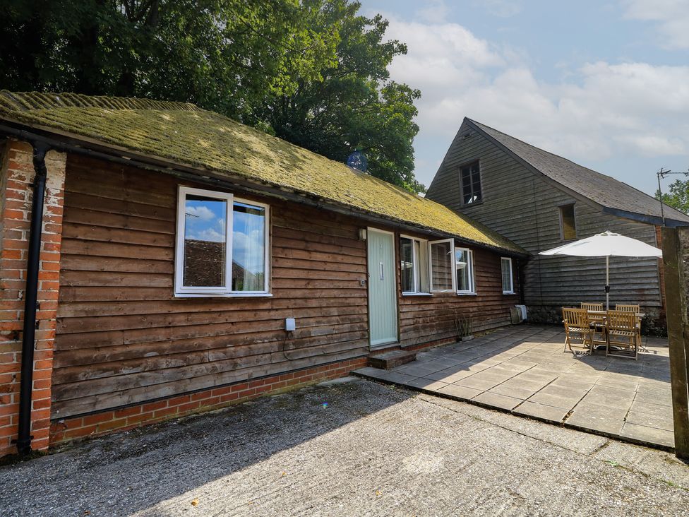 An outdoor view of a cottage with patio furniture at Byre Cottage 2 Sullington near Storrington