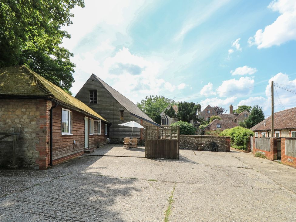An outdoor area with a patio table and umbrella at Byre Cottage 2 Sullington near Storrington