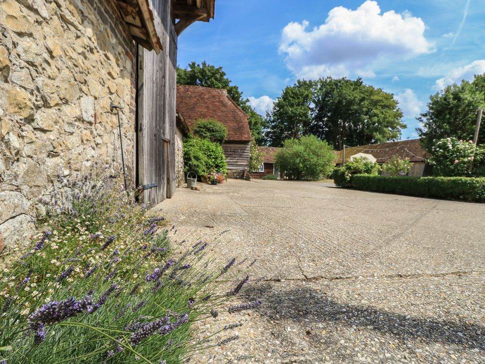 An outdoor area with stone walls and lavender plants at Byre Cottage 2 Sullington near Storrington
