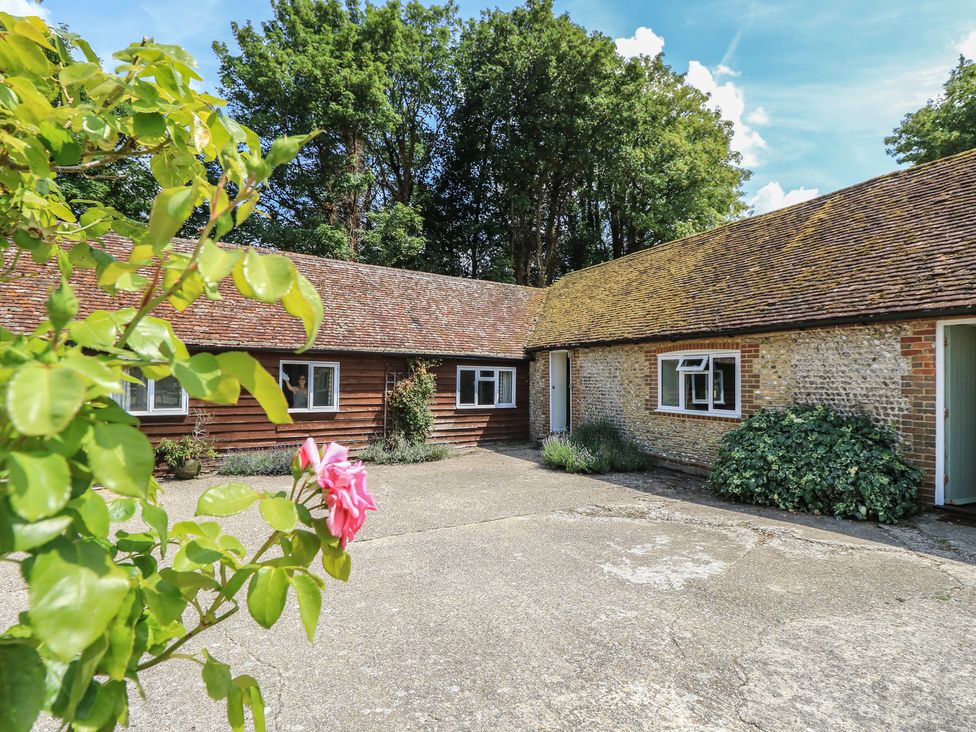 An outdoor area with buildings and a flower at Byre Cottage 2 Sullington near Storrington