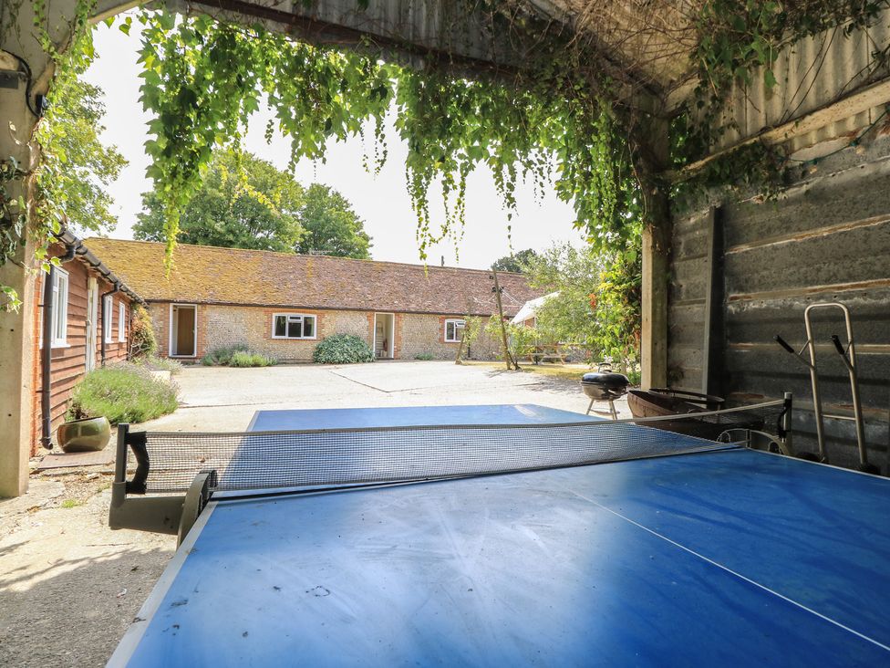 A view of a table tennis table with a garden and buildings at Byre Cottage 2 Sullington near Storrington