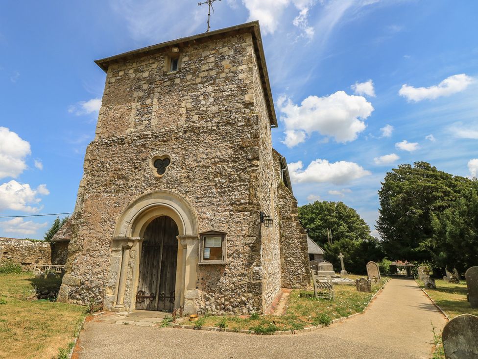 A stone church with a wooden door and pathway at Byre Cottage 2 Sullington near Storrington