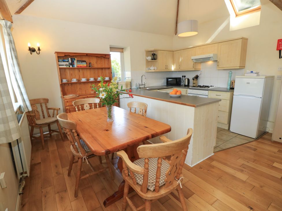 A kitchen with a wooden table and chairs at Byre Cottage 2 Sullington near Storrington