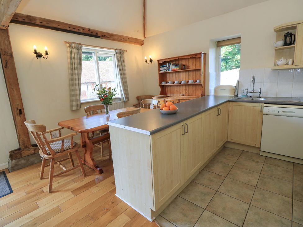 A kitchen with a dining table and chairs at Byre Cottage 2 Sullington near Storrington