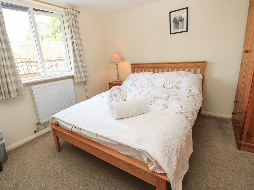 A bedroom with a bed and lamp at Byre Cottage 2 in Sullington near Storrington