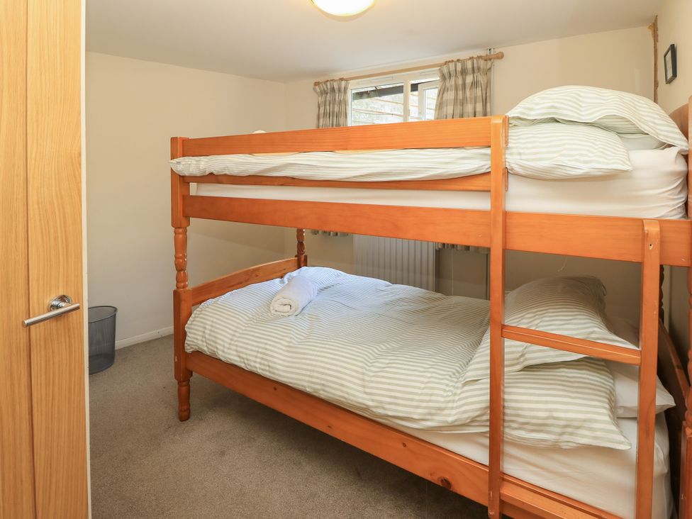 A bedroom with a bunk bed and linens at Byre Cottage 2 Sullington near Storrington