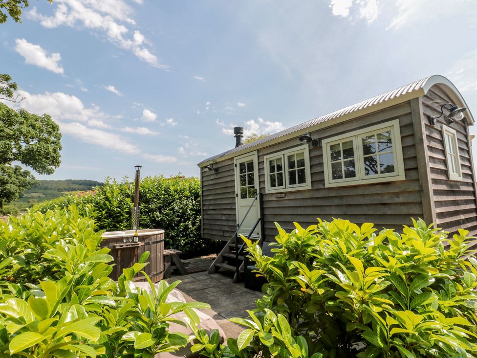 A wooden cabin with a hot tub and steps at Acorn in Bleadon