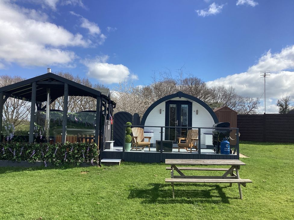 A garden with a pod and seating area at Cherry Pod Hookagate near Meole Brace
