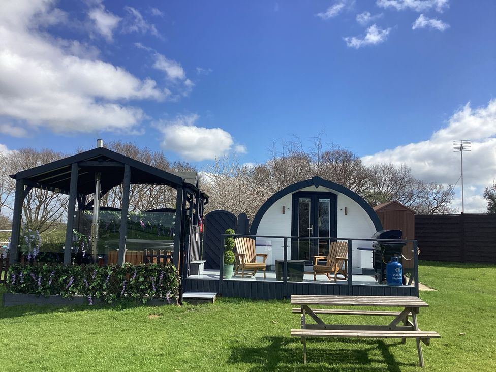A cabin with a deck and chairs at Cherry Pod near Hookagate Meole Brace
