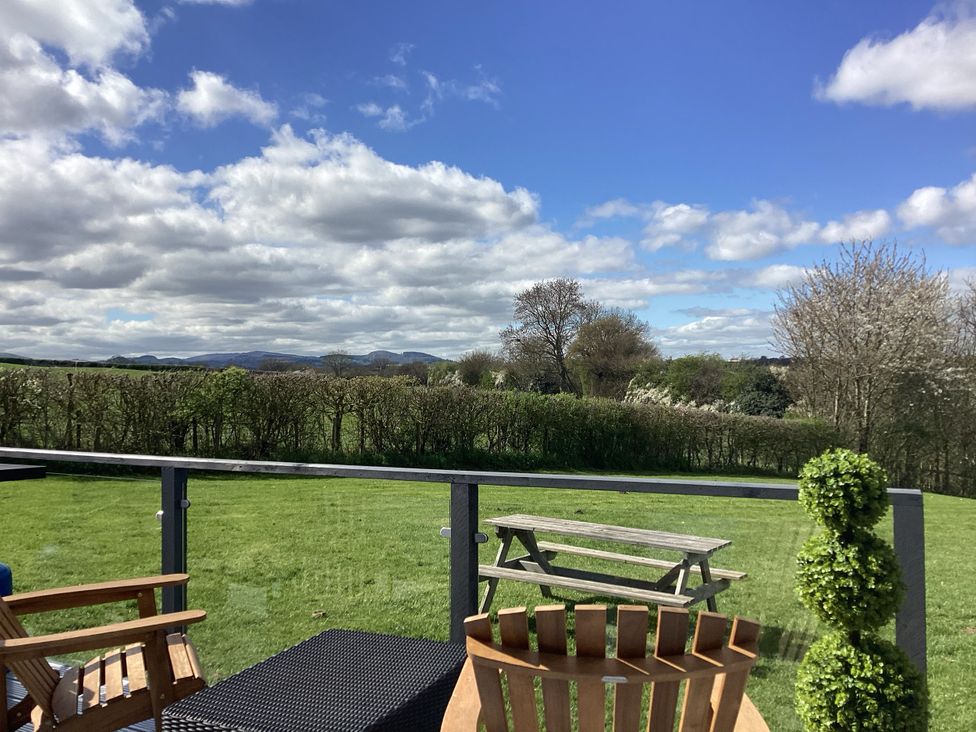 An outdoor seating area with a view of mountains at Cherry Pod Hookagate near Meole Brace
