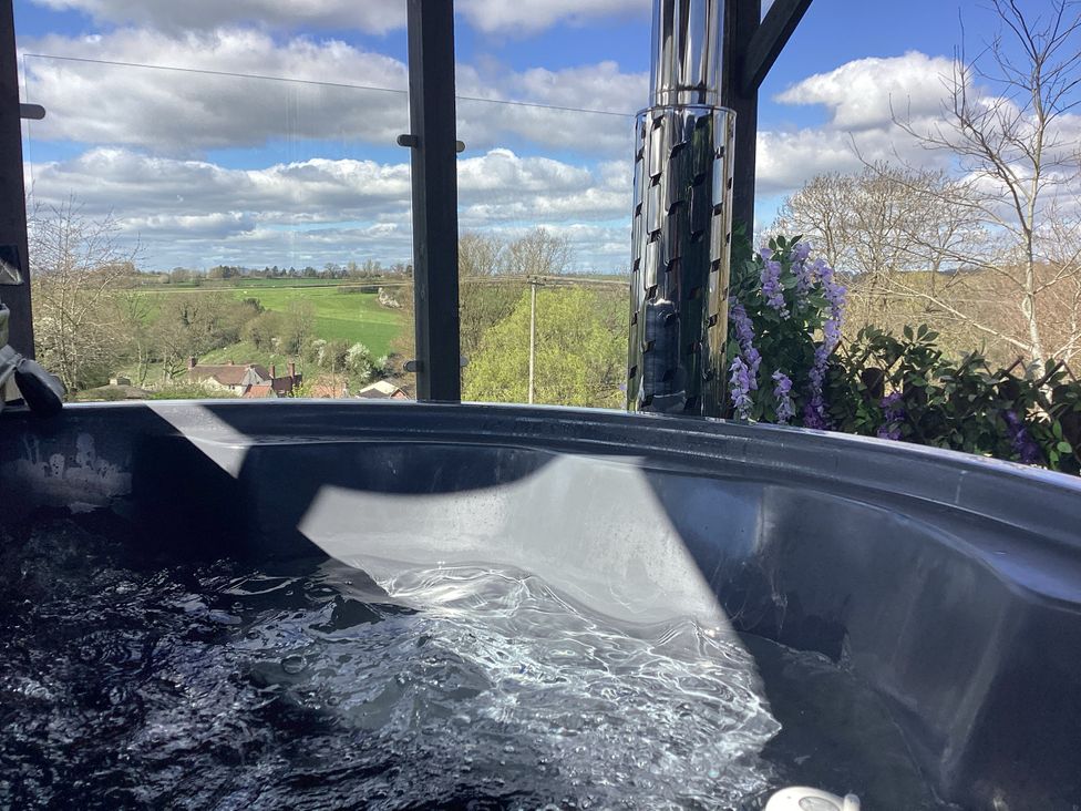A hot tub with water and a view of fields at Cherry Pod Hookagate near Meole Brace