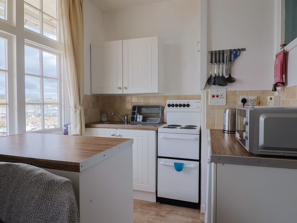 A kitchen with a sink stove and microwave at Flat F 