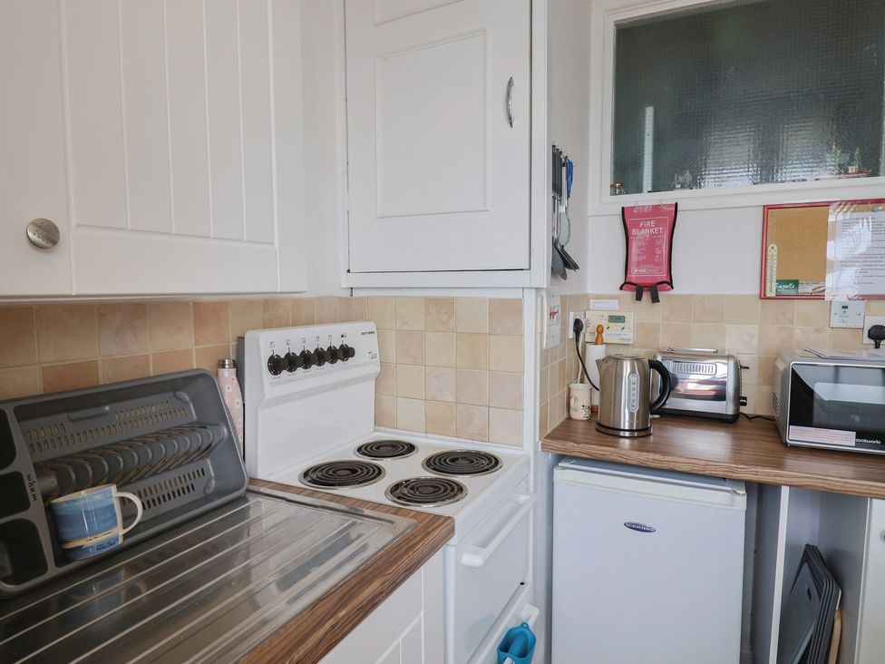 A kitchen with stove and appliances at Flat F 