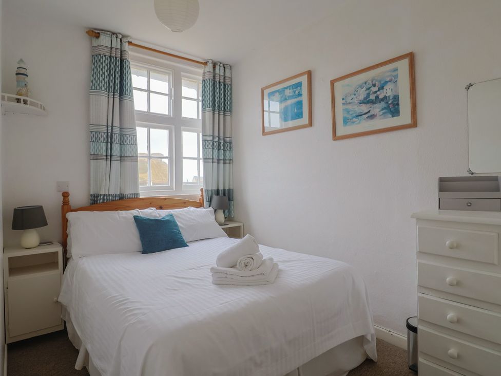 A bedroom with a bed and curtains at Flat F Bay House West Bay