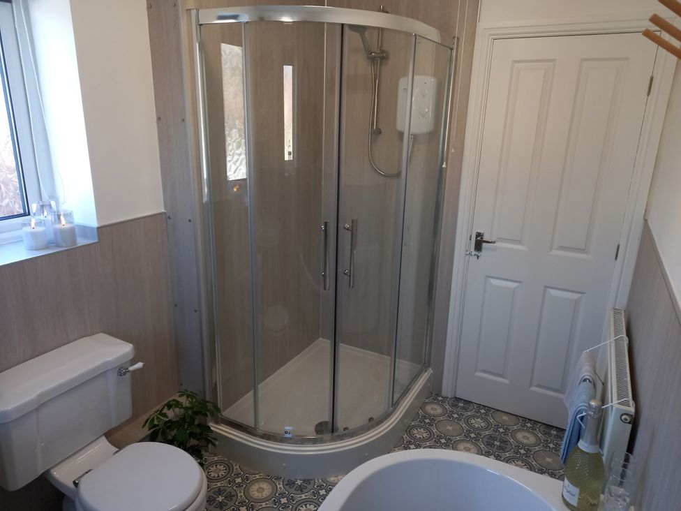 A bathroom with a shower and toilet at Postman's Cottage in Bridlington