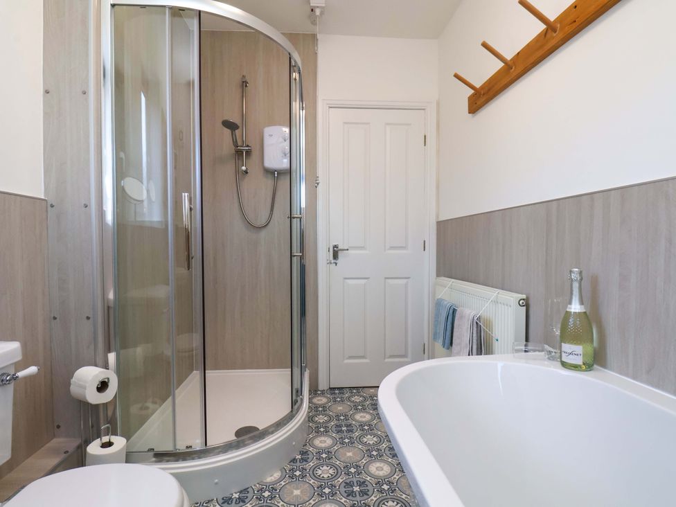 A bathroom with a shower and bathtub at Postman's Cottage in Bridlington