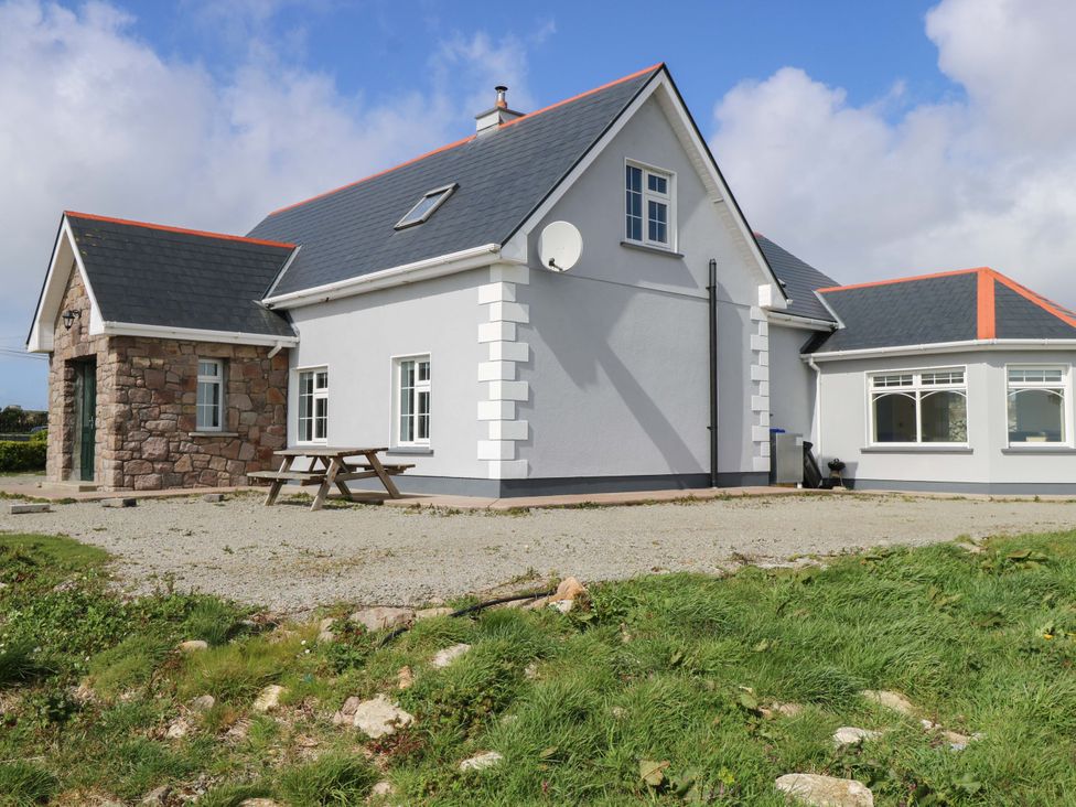 A house with a satellite dish and gravel area at Tí Tom Nárta in Trabane near Lettermore, County Galway