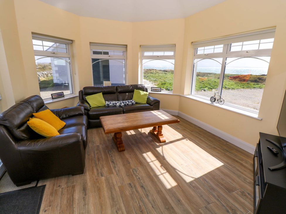 A snug with a sofa and coffee table at Tí Tom Nárta, Trabane near Lettermore, County Galway