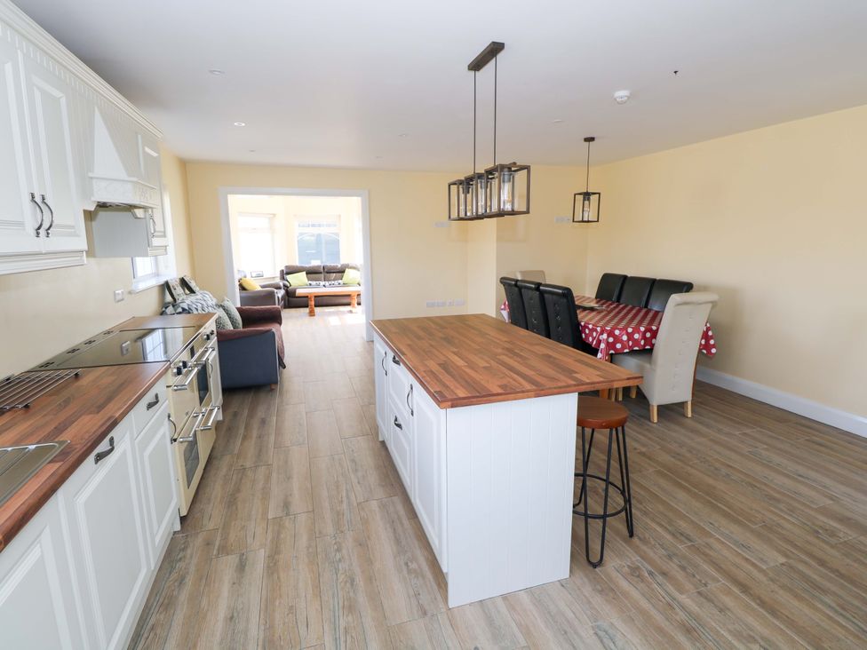 A kitchen with an island and dining area at Tí Tom Nárta, Trabane near Lettermore, County Galway