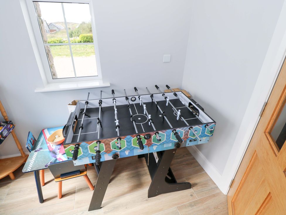 A foosball table with a chair at Tí Tom Nárta Trabane near Lettermore County Galway