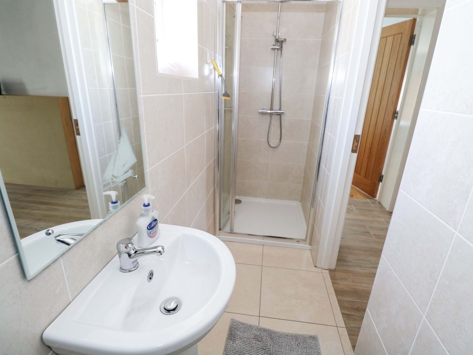 A bathroom with a sink and shower at Tí Tom Nárta in Trabane near Lettermore, County Galway