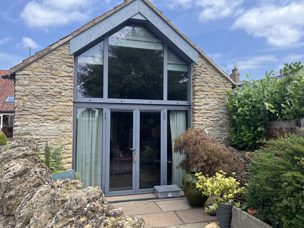 An entrance with glass doors and plants at The Nail Shed in East Ayton