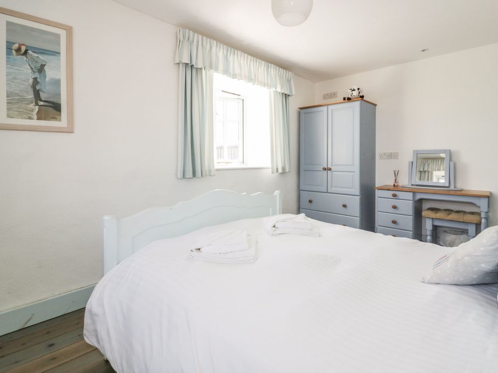A bedroom with a bed and wardrobe at Owls Roost in Gorran Haven