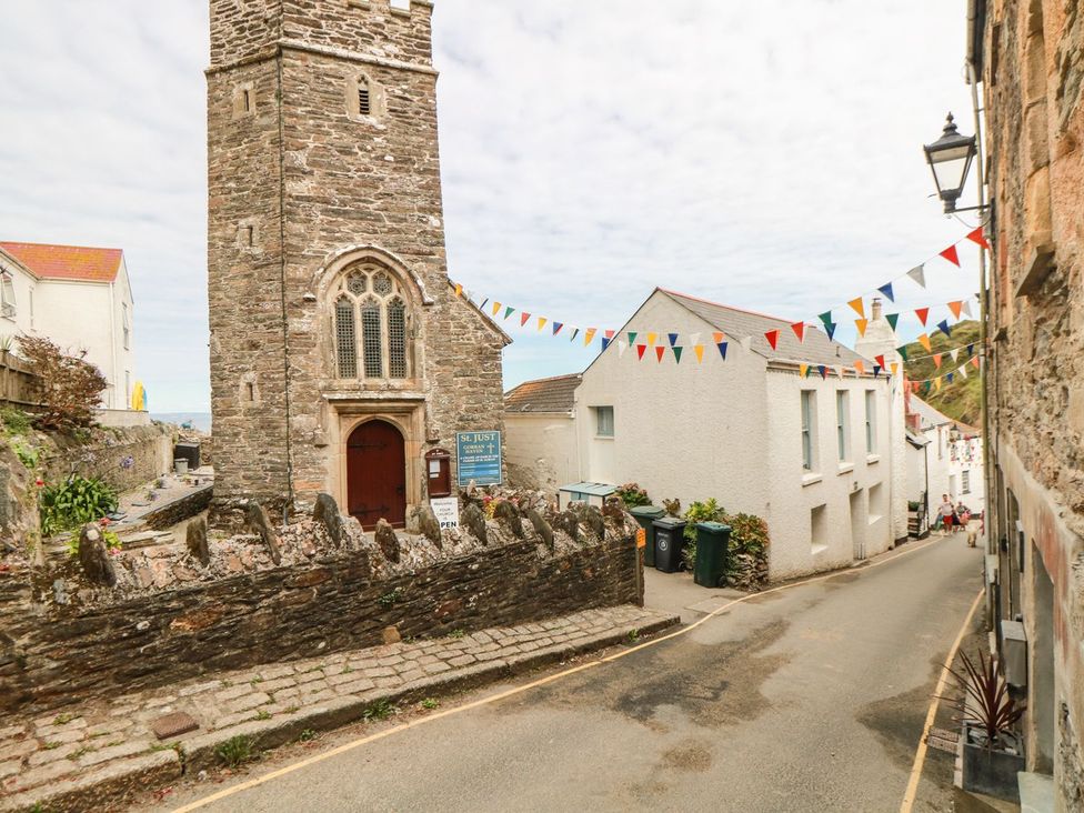 A stone church with bunting in a street at Squirrels Dray in Gorran Haven
