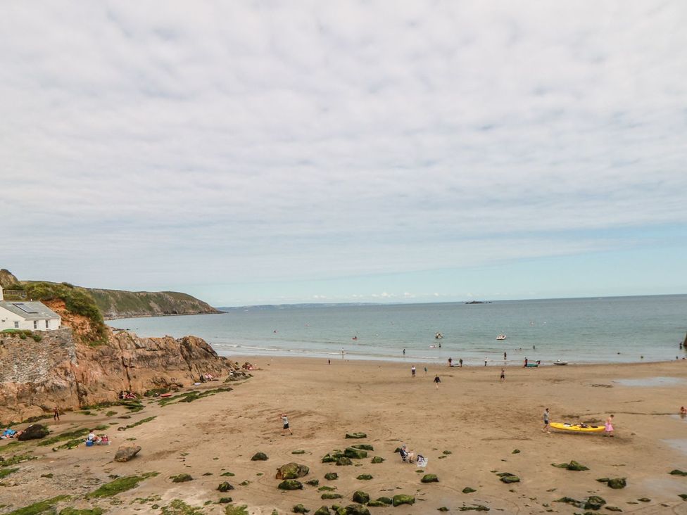 A beach with people and boats at Squirrels Dray in Gorran Haven