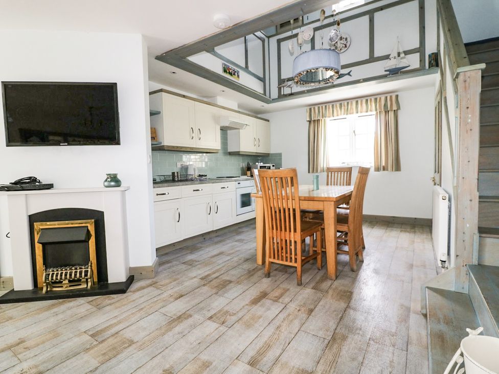 A kitchen with dining table and appliances at Squirrels Dray in Gorran Haven