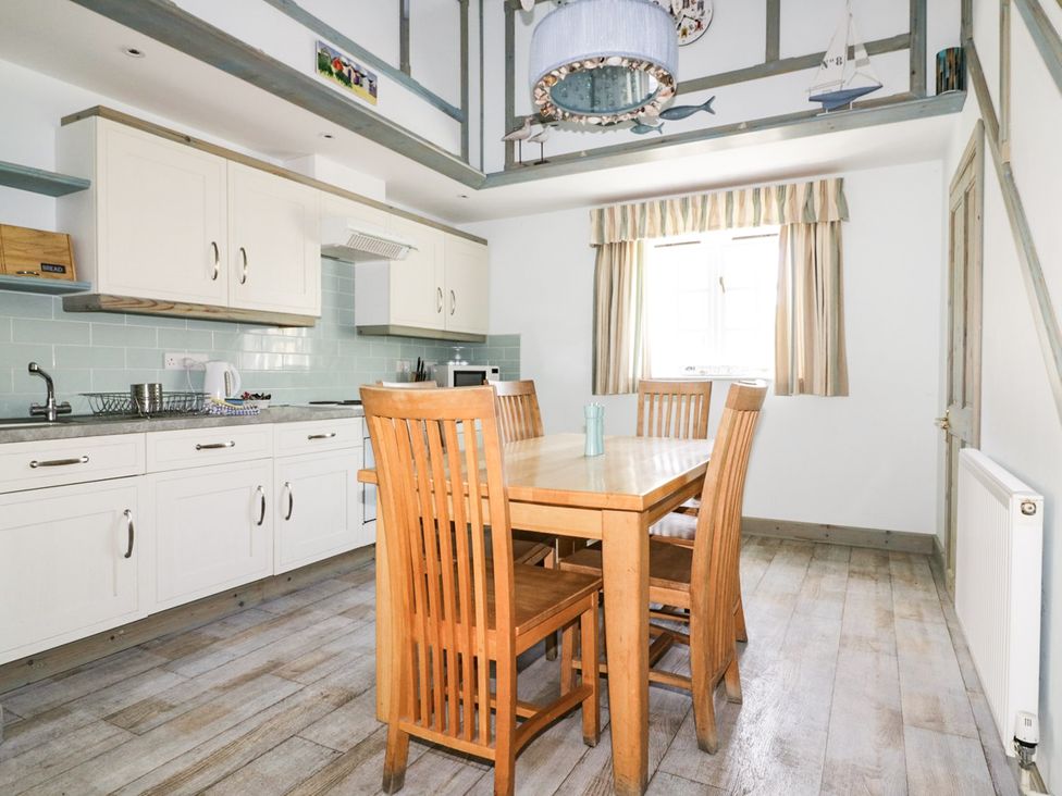 A kitchen with a dining table and chairs at Squirrels Dray in Gorran Haven