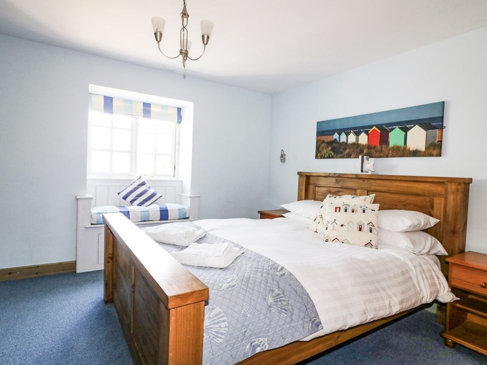 A bedroom with a bed and window at Squirrels Dray, Gorran Haven
