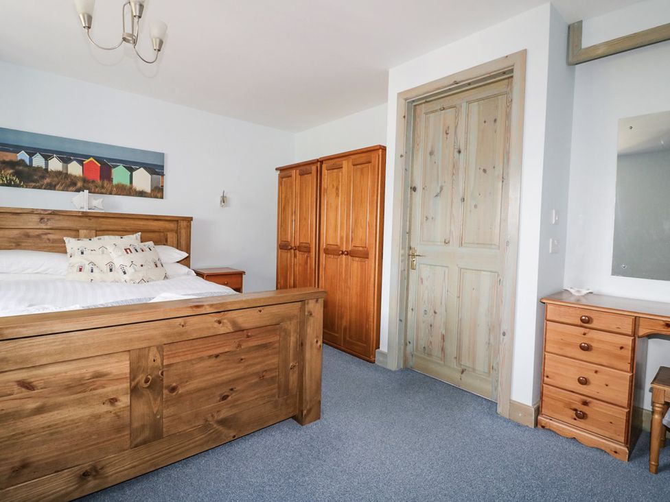 A bedroom with a bed and wardrobe at Squirrels Dray in Gorran Haven