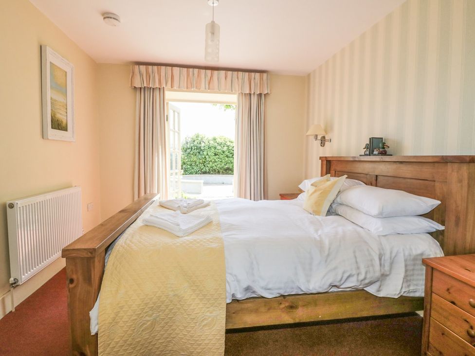 A bedroom with a bed and window at Foxes Den in Gorran Haven