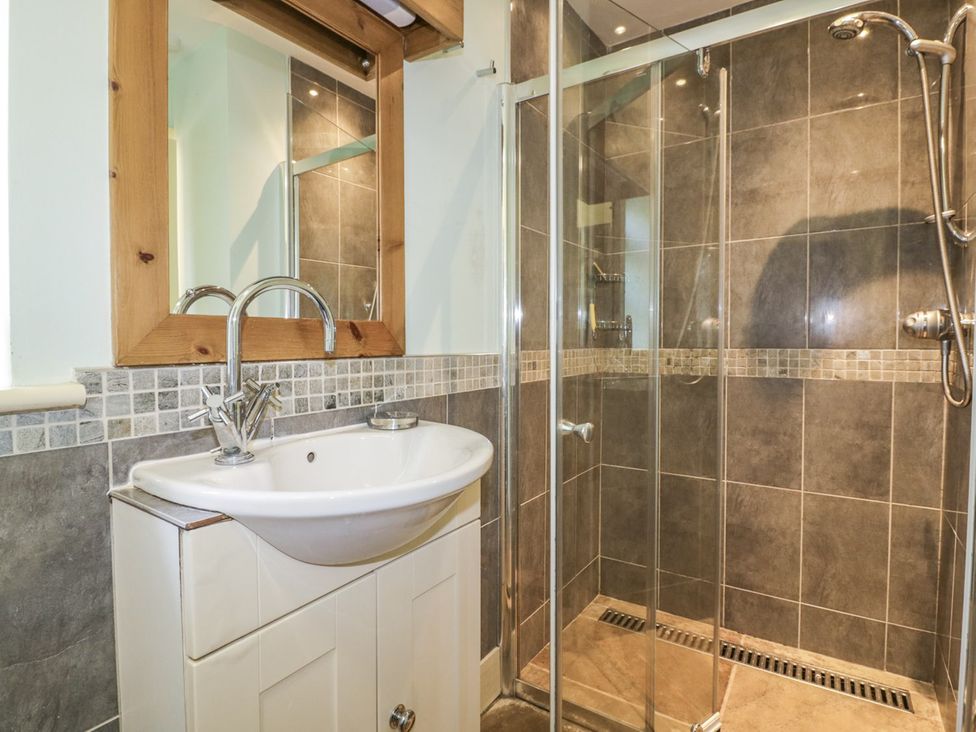 A bathroom with a sink and a shower at Foxes Den in Gorran Haven