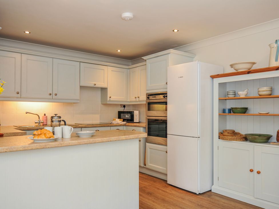 A kitchen with a sink and refrigerator at Samphire in Rock
