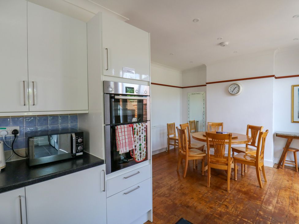 A kitchen with microwave and dining table at Ninety Eight Southend-On-Sea
