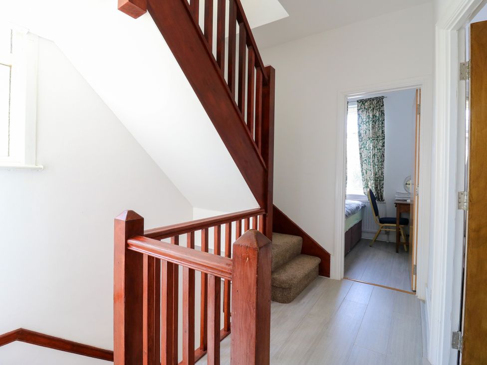 A staircase leading to a hallway with a door and window at Ninety Eight Southend-On-Sea