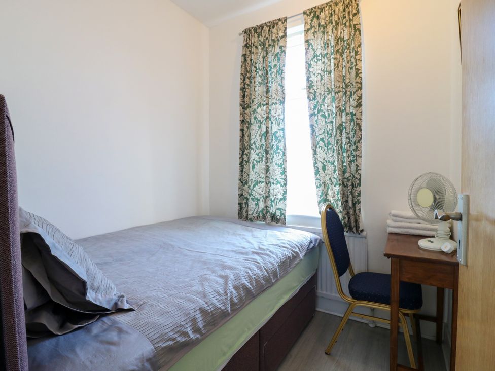 A bedroom with a bed, table, chair and window at Ninety Eight Southend-On-Sea