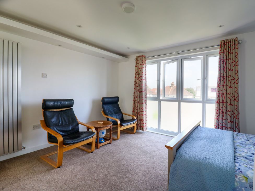 A bedroom with armchairs and a bed at Ninety Eight in Southend-On-Sea