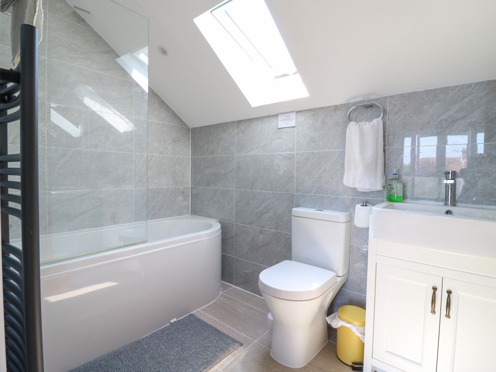 A bathroom with a bathtub, toilet, sink, and towel holder at Ninety Eight in Southend-On-Sea