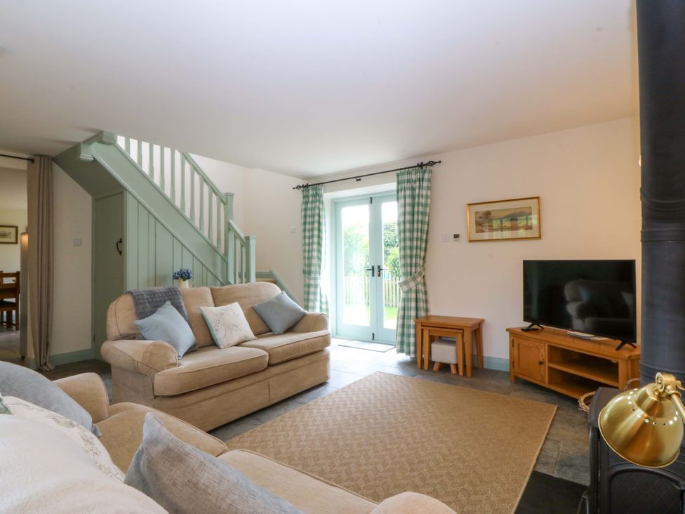 A living room with a sofa and television at No 2 The Stables Capel Coch near Llannerch-Y-Medd