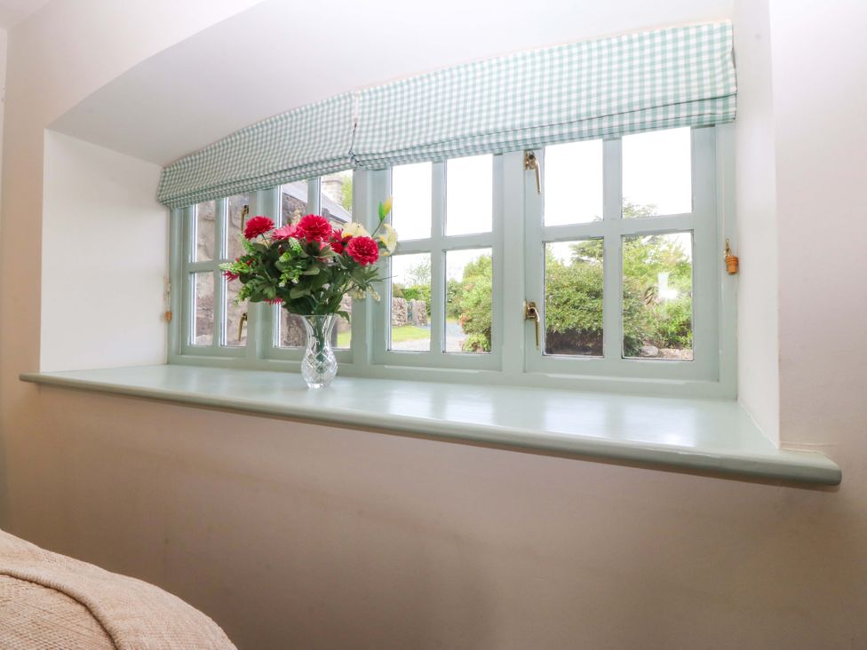 A window with a flower vase on the sill at No 2 The Stables Capel Coch near Llannerch-Y-Medd