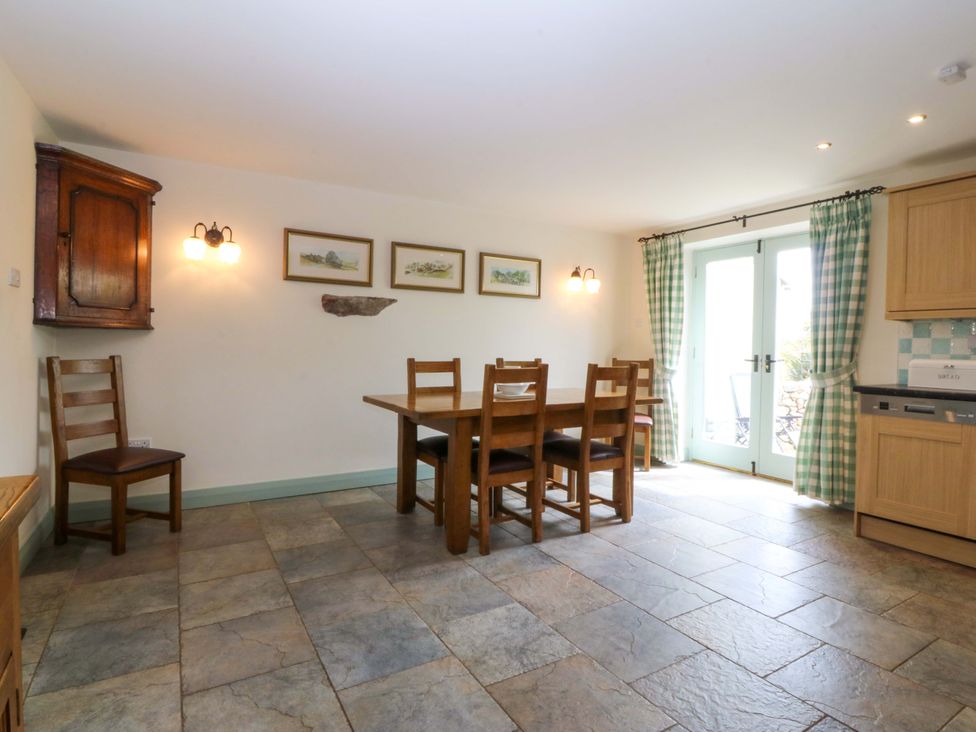 A dining room with a table and chairs at No 2 The Stables Capel Coch near Llannerch-Y-Medd