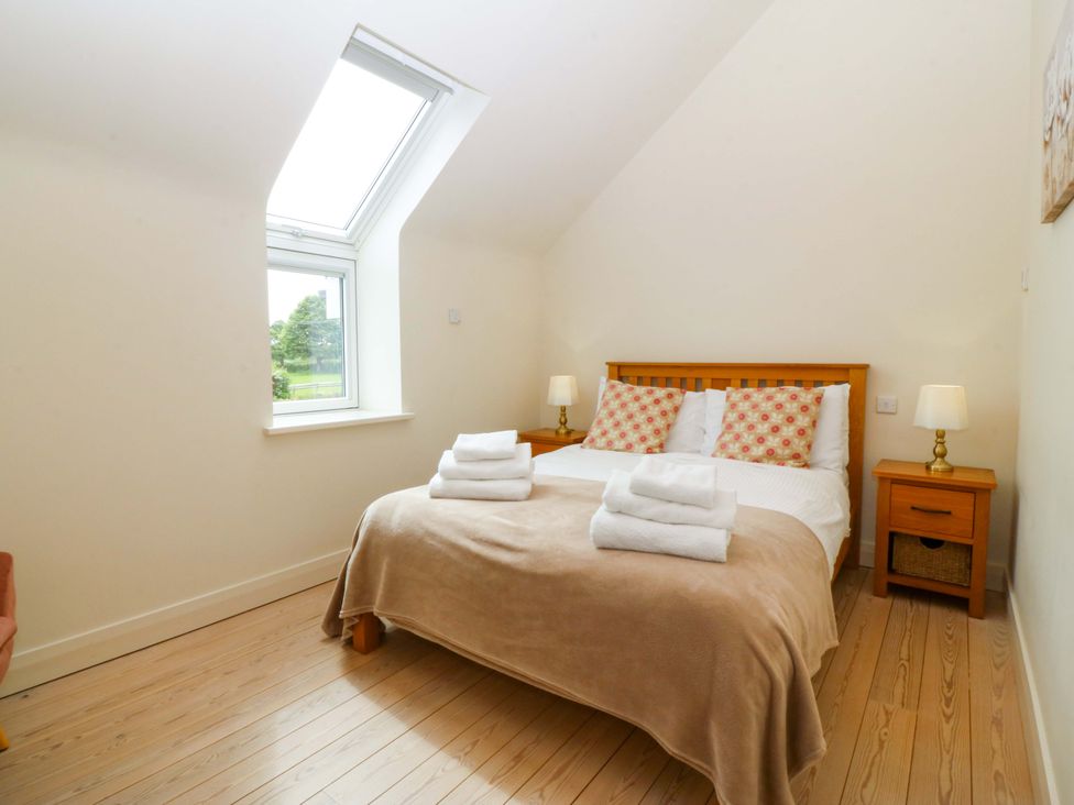 A bedroom with a bed and bedside tables at No 2 The Stables Capel Coch near Llannerch-Y-Medd